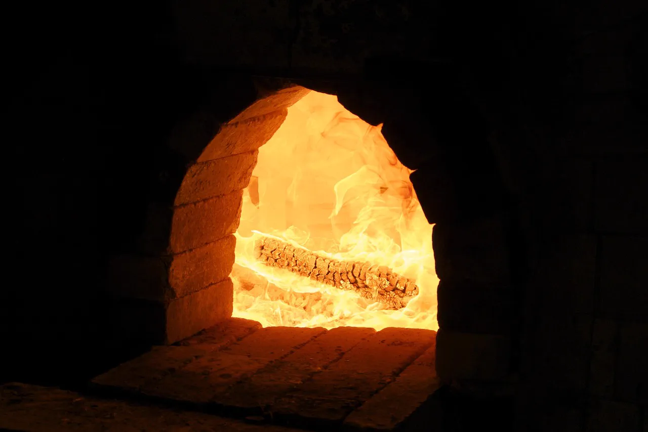 Foc de lemne aprins într-un cuptor de cărămidă